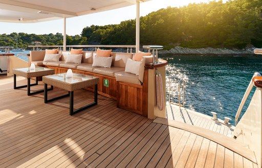 Aft deck onboard private yacht charter QUEEN ELEGANZA with seating to port and steps leading down to swim platform