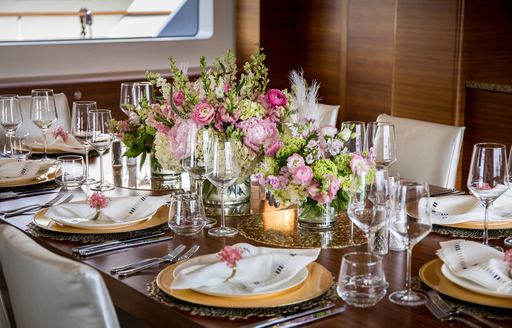 A tablescaping entry in a competition, pink florals decorate a long dark wood dining table
