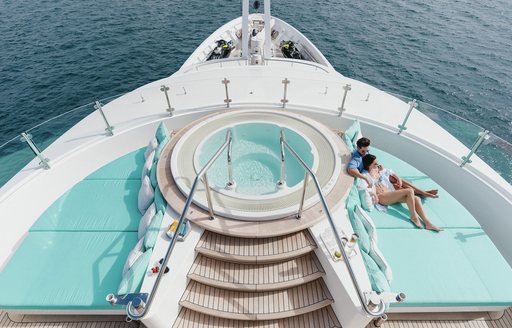 Jacuzzi pool with people on sun pads on board luxury yacht Ramble on rose