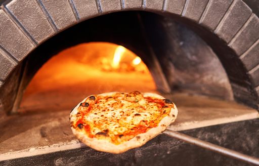Pizza making using a traditional clay-fired oven in Naples, Italy