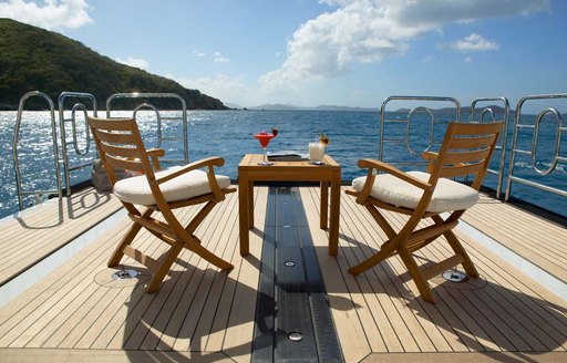 Two chairs and small table with cocktails on lazarette of luxury yacht Harle