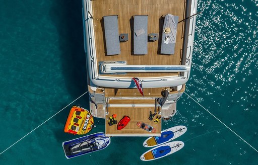 Aerial view looking down on the aft decks of charter yacht KLOBUK, with water toys adjacent to swim platform