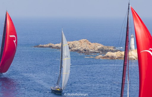 Sailing yachts on the water off the coast of Porto Cervo, undertaking a regatta
