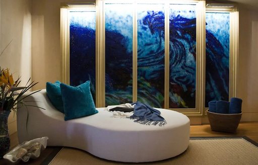 Comfortable seating in front of unusual art panels on superyacht Sea Rhapsody