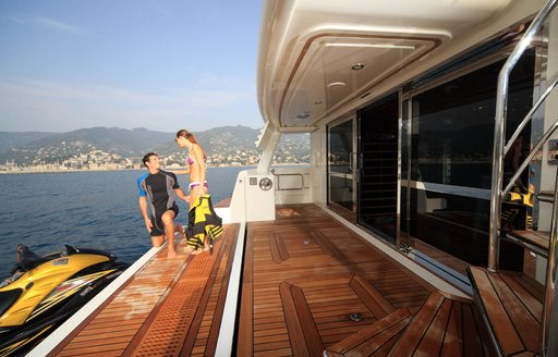 charter guests on the swim platform of luxury yacht HANA