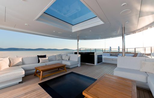 Sundeck of luxury yacht SAMURAI, with skylight in ceiling, white sofas and jacuzzi pool in background