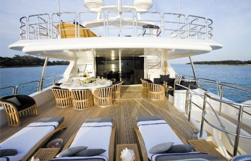 sun loungers and dining table on the upper deck aft of charter yacht SEABLUE’Z