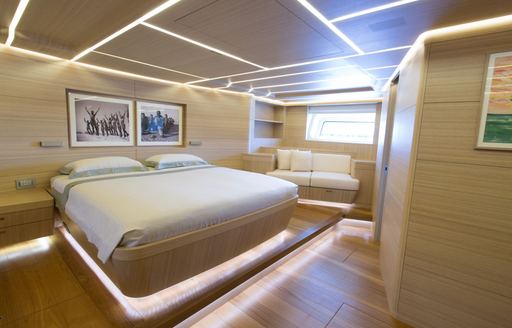 Overview of the master cabin onboard charter yacht OHANA, central berth with seating in the background