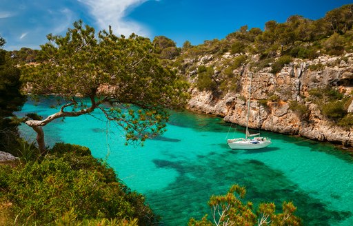 Sail yacht anchored in turquoise waters in the Balearics