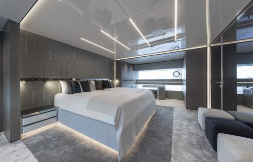 Overview of the master cabin onboard superyacht NO STRESS TWO, central berth facing starboard with wide window in the background.