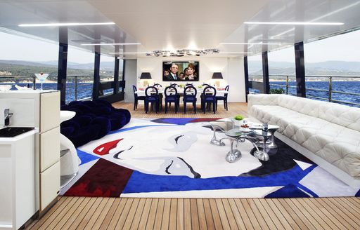 Main salon with wide windows and white sofas aboard luxury yacht BLADE