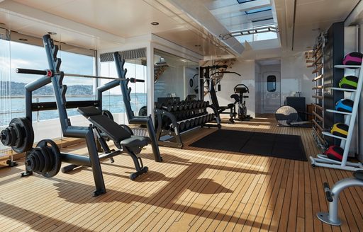 bench press insidethe gym of luxury superyacht JOY as the sun bleeds in from their panoramic window installation 