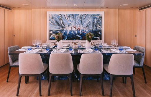 Interior dining area onboard charter yacht ISLANDER II, long table with 10 seats surrounding
