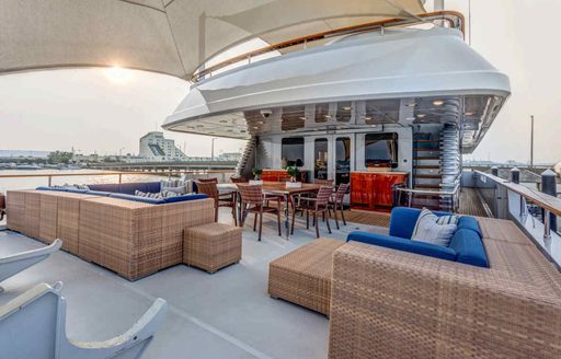 Sun deck onboard charter yacht HELIOS 2 with ample exterior seating and a bimini
