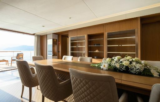 Interior dining set up onboard charter yacht ALFA with fold-down balcony visible in the background