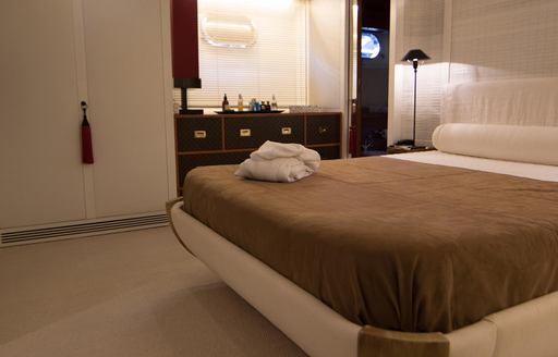 Guest cabin onboard charter yacht SEVEN STARS, central berth with brown blanket