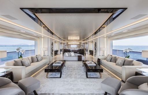 Main salon onboard charter yacht PARILLION, extensive lounge area surrounded by huge wide-stretched windows on either side