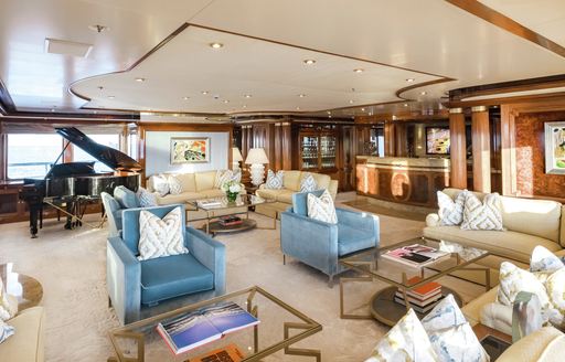 Main salon onboard superyacht charter TITANIA, with spacious lounge and a grand piano