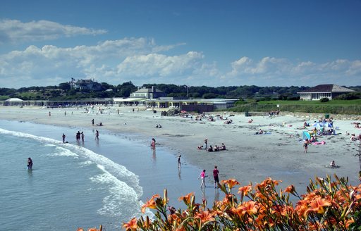 Sandy beach in New England, with people splashing in the waves