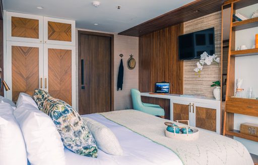 Cabin onboard charter yacht KONTIKI WAYRA, central berth facing a wall with wall-mounted TV.