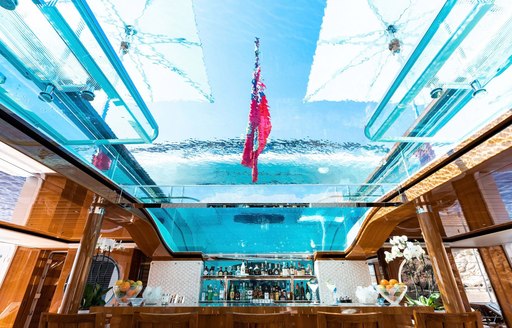 glass bottomed swimming pool on superyacht faith, with umbrellas and bar 