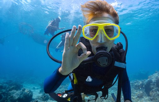 A diver uses the international "okay" sign