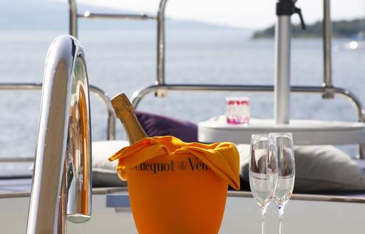 Bottles of champagne and flutes by the jacuzzi on sundeck of superyacht CASSIOPEIA