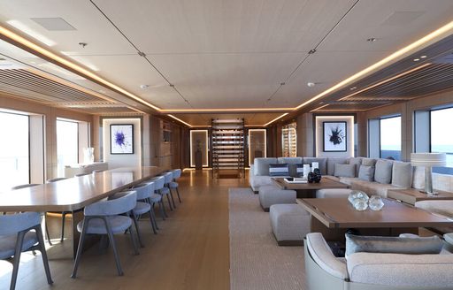 Overview of the main salon onboard charter yacht ALCHEMY, lounge area to starboard and dining table to port
