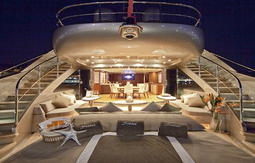 View of sun pads and seating on main deck aft of superyacht Soiree with dining salon in background