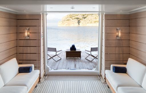 Overview of a fold down balcony onboard charter yacht AQUILA, with white seating in the foreground