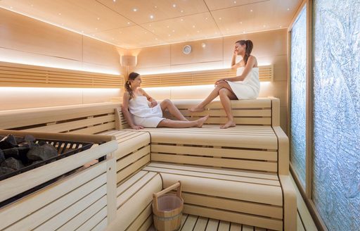 two women relax in the suana of their superyacht