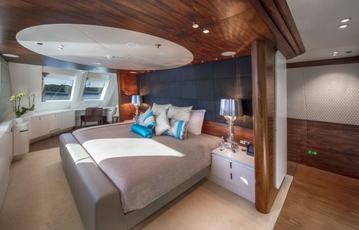 guest cabin on superyacht KATINA with large skylight above bed and polished wood accents