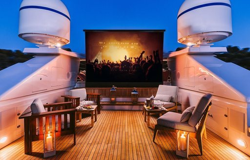 Overview of the outdoor cinema onboard charter yacht NATALIA V, large screen central with plush seats adorning the deck
