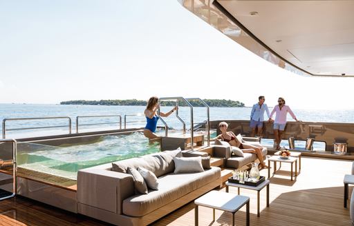 a family enjoying the pool of their luxury charter yacht