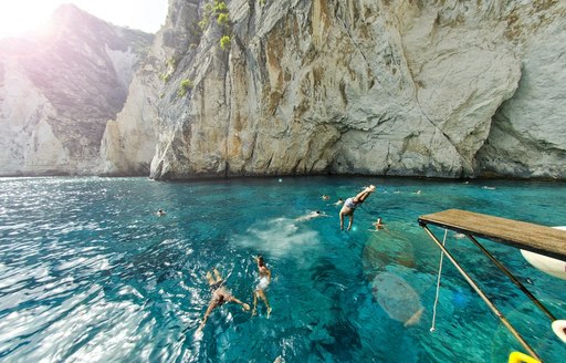 Swimmers enjoying the clear waters near the blue caves in Zakynthos, Greece
