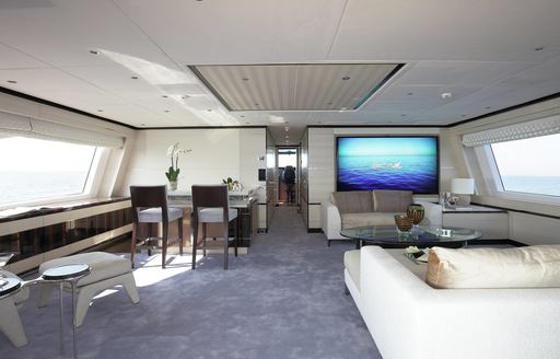upper salon with bar, seating and 75-inch TV on board charter yacht SKYLER 