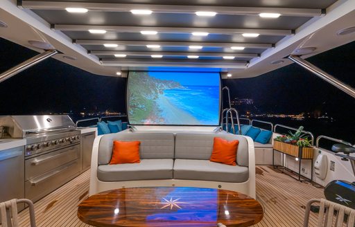 Exterior cinema screen with sofa onboard Benetti yacht charter AMADEA