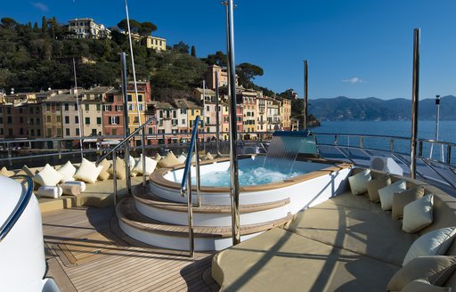 An image which shows the Jacuzzi on a superyacht with Portofino in the background