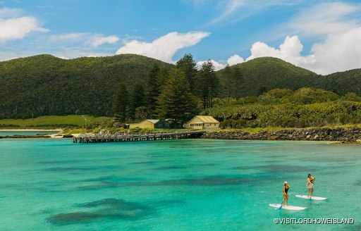 Paddleboarders enjoy the calm blue waters on Lord Howe Island, Australia