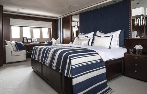 master suite with navy blue and white colour palette and rich wooden panelling on board charter yacht CRISTOBAL 