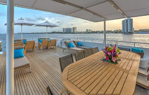 alfresco dining area and teak loungers on the upper deck aft of charter yacht LIONSHARE