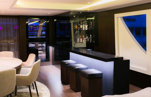 bar with three bar stools in upper deck salon of superyacht SAHANA 