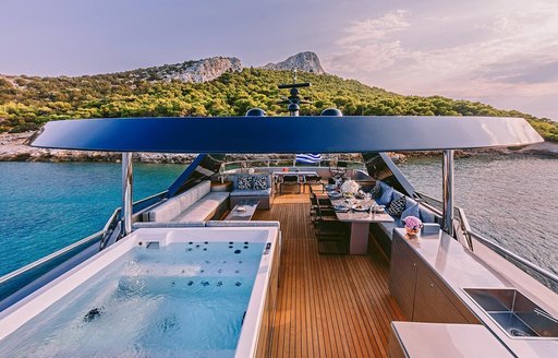 Overview of the flybridge onboard charter yacht OVAL, with deck Jacuzzi and ample seating