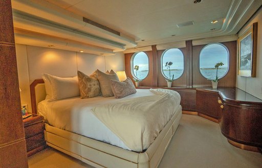 Master cabin onboard charter yacht NEVER ENOUGH, central berth with three round windows in the background