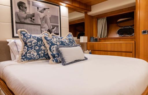 Guest cabin onboard charter yacht ESSOESS, central berth facing forward with small hull window in the background 