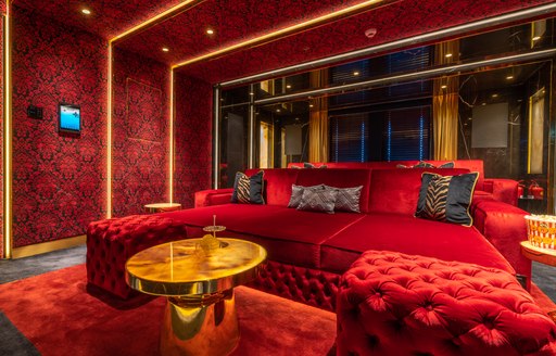Overview of interiors onboard superyacht LEONA. Deep red furnishings and decor.