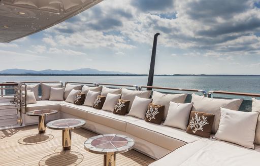 Large U-shaped seating arrangement with three coffee tables on the aft deck onboard charter yacht PARILLION