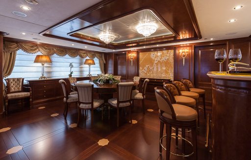 games table and bar in the classically styled skylounge aboard motor yacht PRIDE