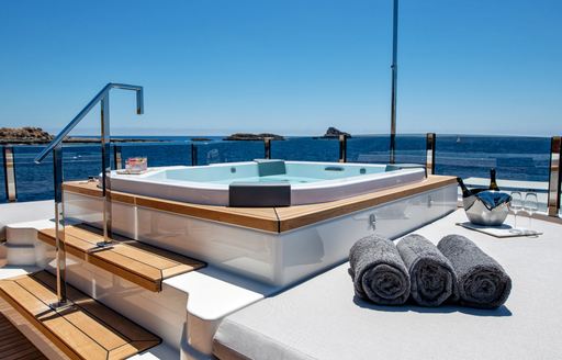 Swimming pool on SANGHA superyacht with steps going up to it and towels next to it