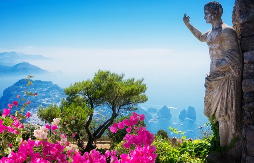 capri, italy with statue in foreground and sea beyond